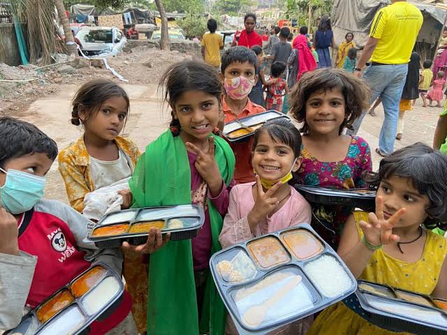 Children receiving food in tiffin boxes